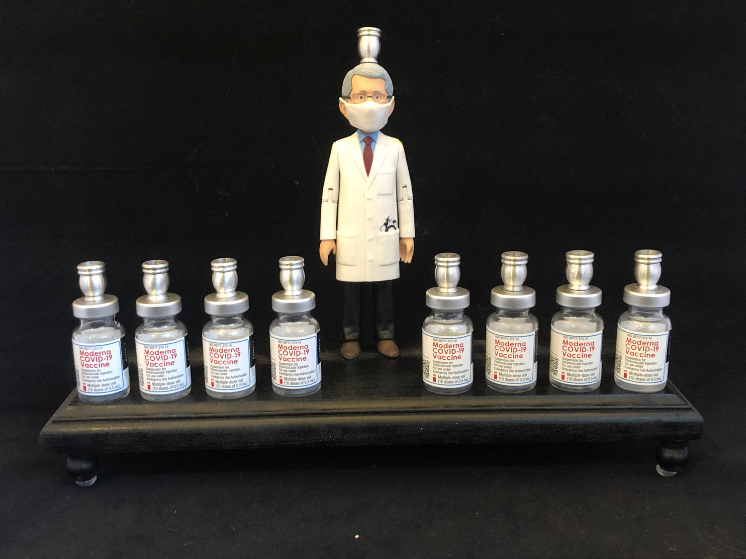 Dr. Fauci Vaccine Menorah — action figure beside repurposed glass vaccine vials | Judaica Square Lakewood (view 8)
