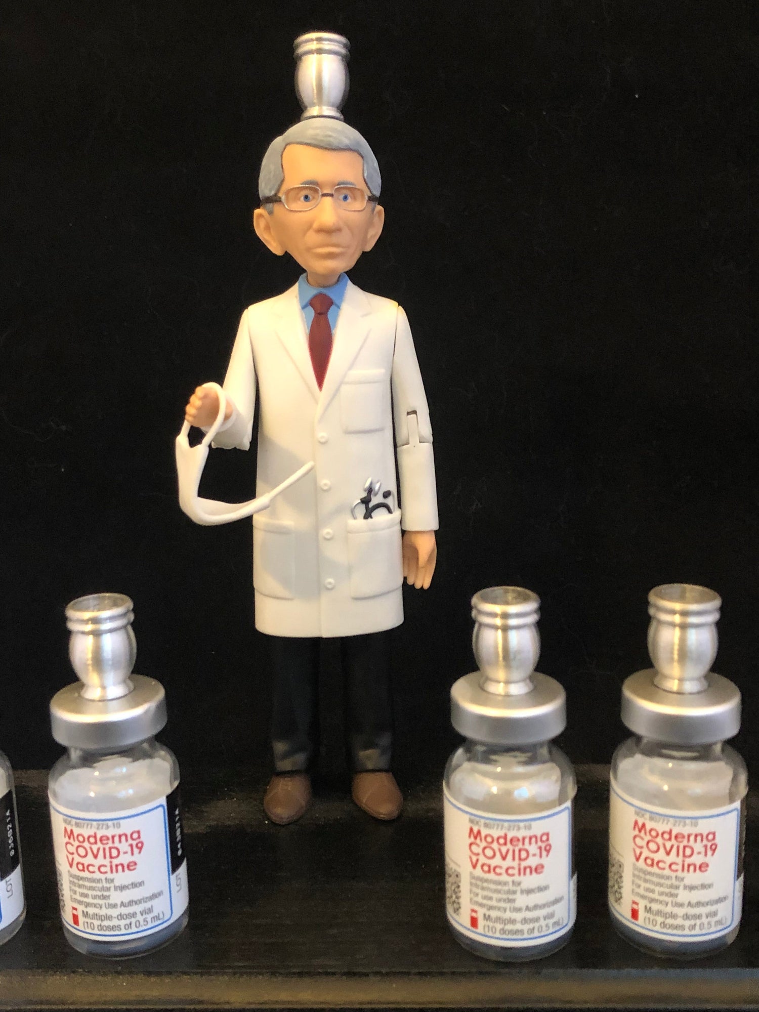 Dr. Fauci Vaccine Menorah — action figure beside repurposed glass vaccine vials | Judaica Square Lakewood (view 9)