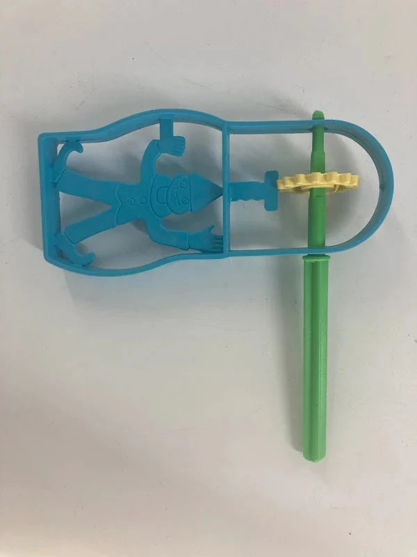 Blue plastic Purim gragger with a molded clown figure in the frame, green handle and yellow ratchet cog