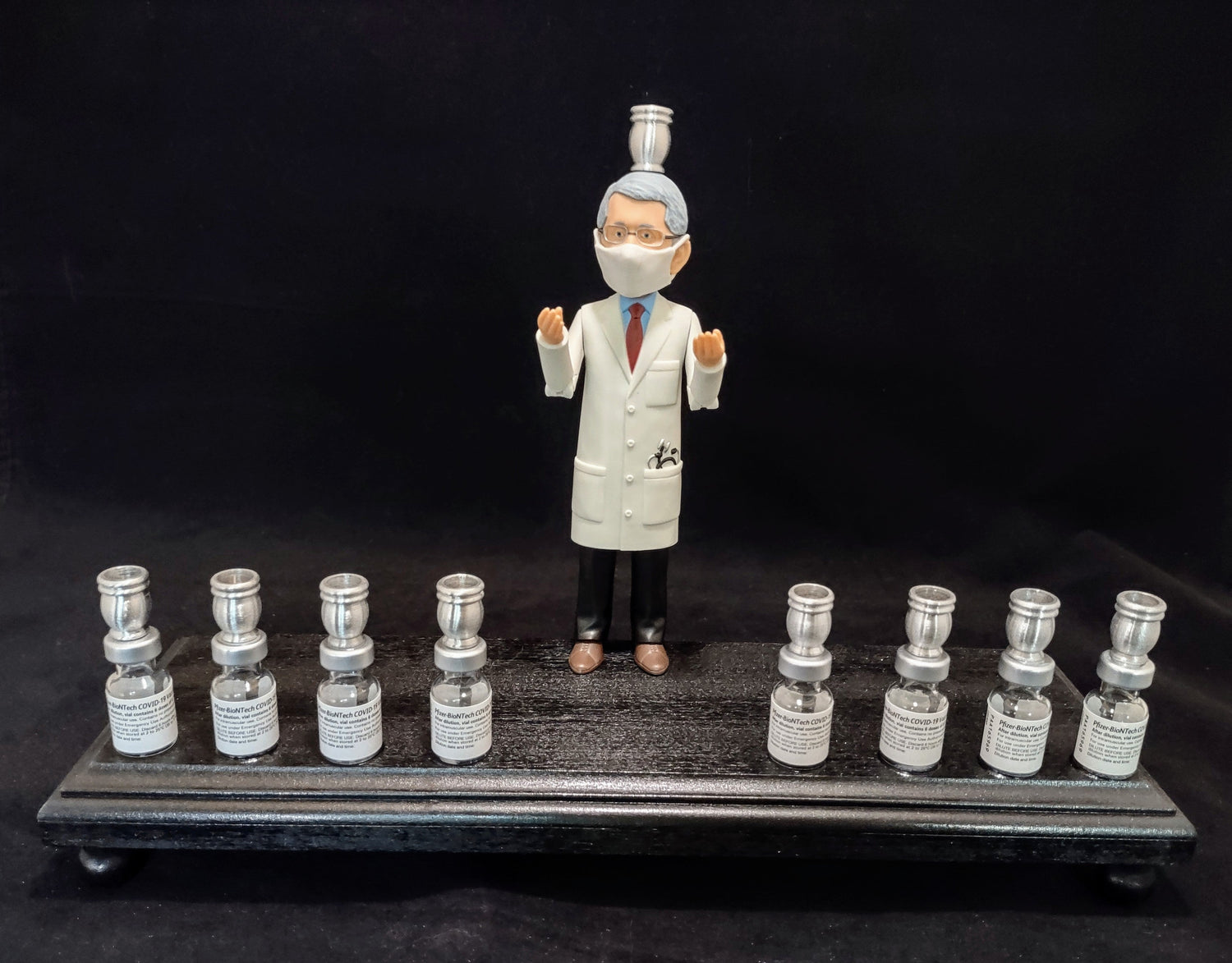Dr. Fauci Vaccine Menorah — action figure beside repurposed glass vaccine vials | Judaica Square Lakewood (view 4)