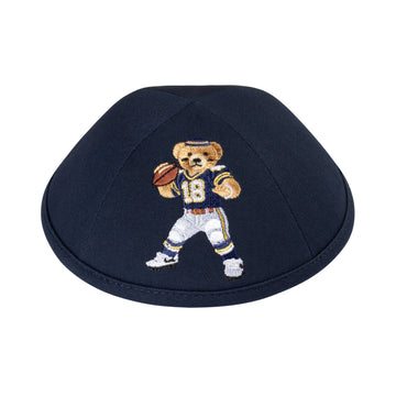 Dark navy cotton boys kippah embroidered with a Dov Bear quarterback in a navy number 18 jersey and white pants holding a football