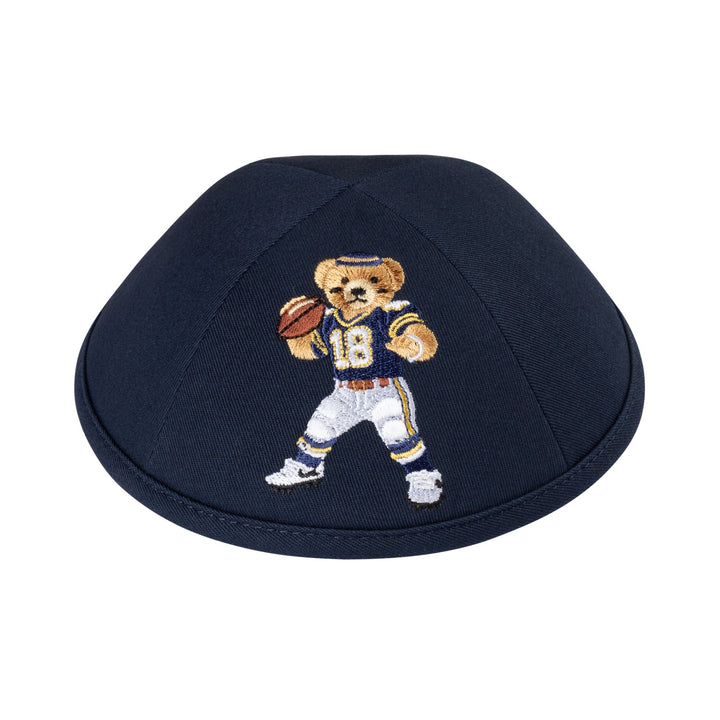 Dark navy cotton boys kippah embroidered with a Dov Bear quarterback in a navy number 18 jersey and white pants holding a football