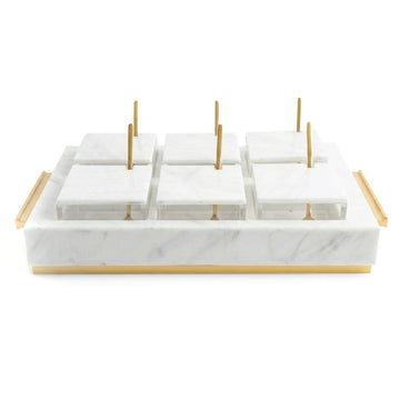 White marble lucite six-bowl dip set with lids on and gold spoons upright