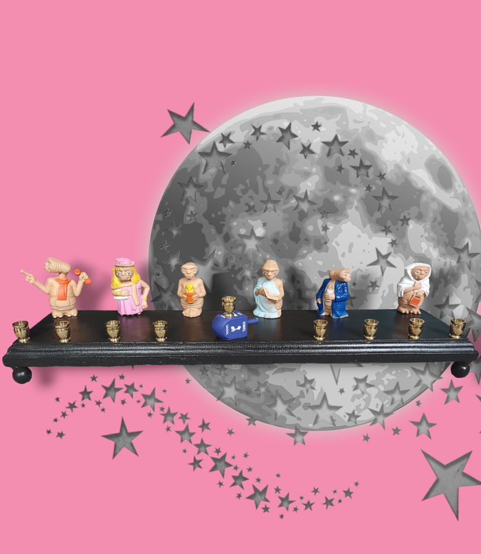 E.T. dress up menorah — six costumed E.T. toy figures along a painted plaque | Judaica Square Lakewood