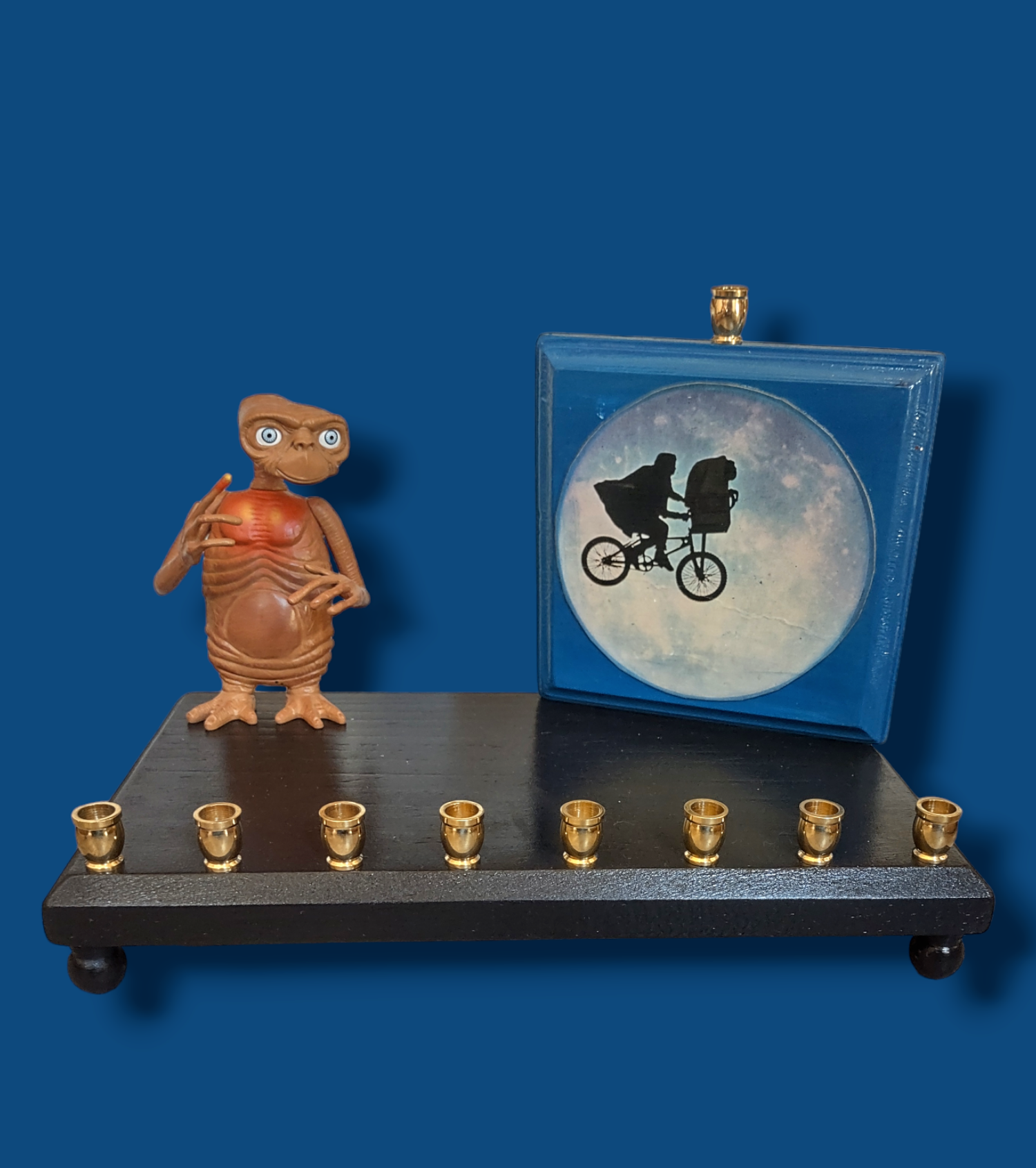 E.T. menorah — repurposed figure beside a hand-painted silhouette on wood | Judaica Square Lakewood (view 6)