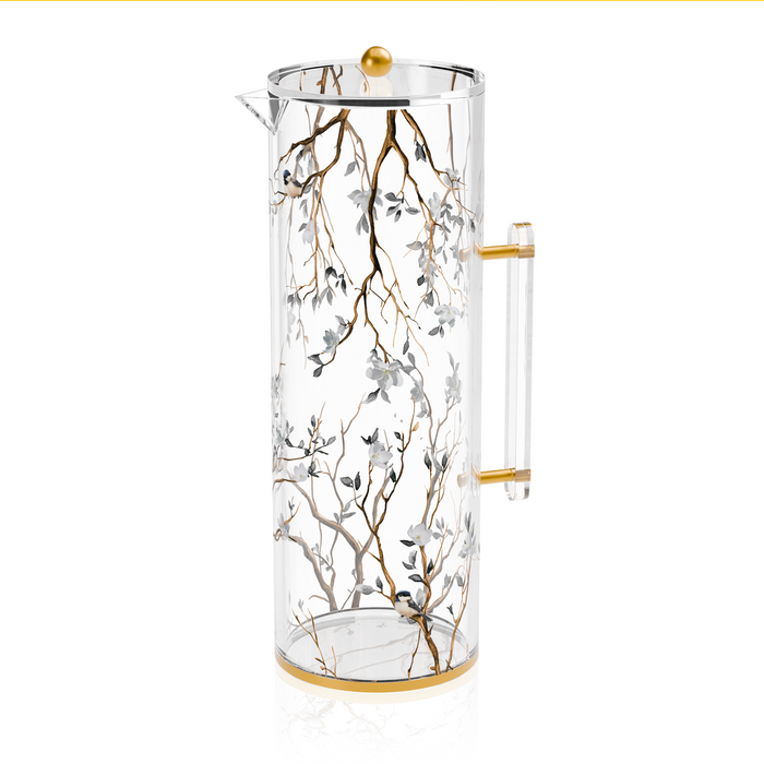 Clear lucite Botanical Blooms water pitcher shown from the side, the floral print wrapping the body between gold-trimmed rims