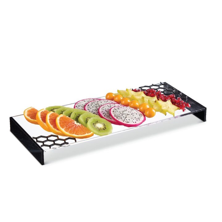 Black-edged lucite honeycomb tray holding a row of sliced fruit
