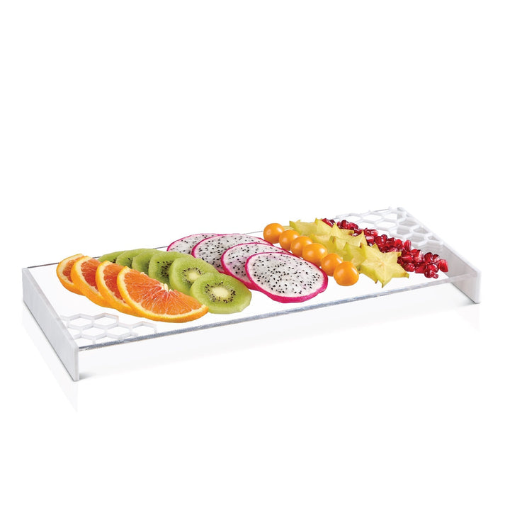 White marble-ended lucite honeycomb tray holding a row of sliced fruit