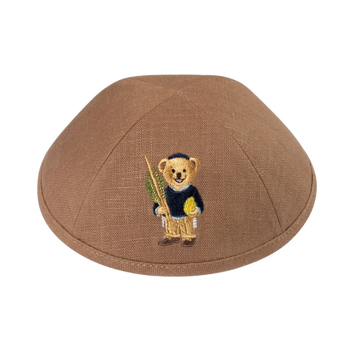 Brown linen boys kippah embroidered with a Dov Bear holding a green lulav and a yellow esrog, wearing a navy sweater and black kippah
