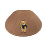 Brown linen boys kippah embroidered with a Dov Bear holding a green lulav and a yellow esrog, wearing a navy sweater and black kippah