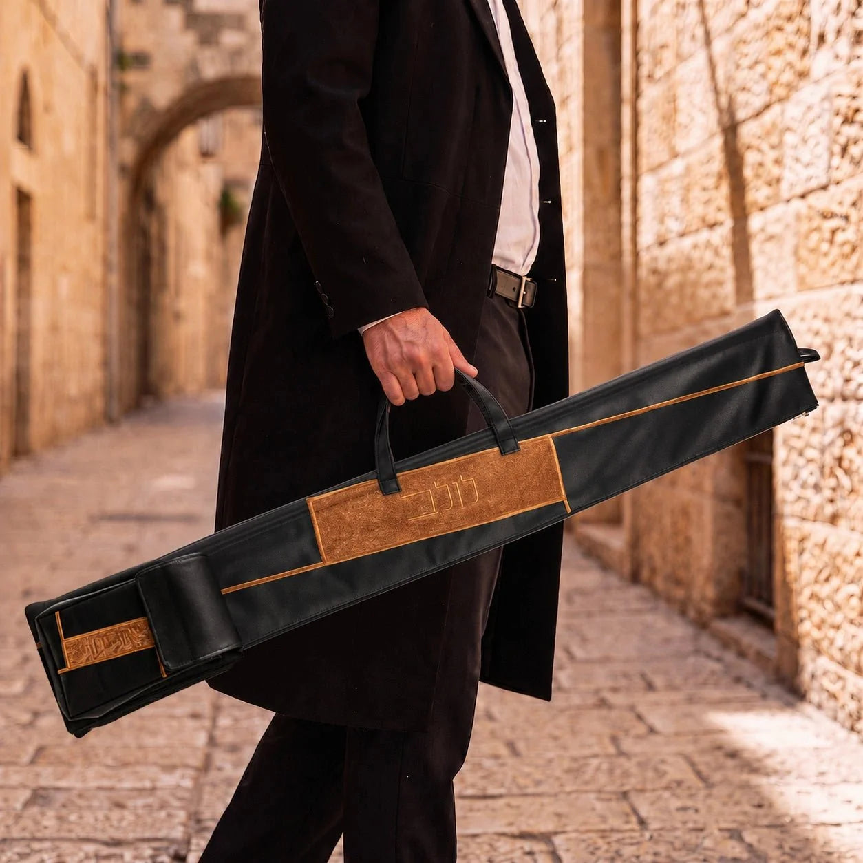 Black Waterdale geometric lulav case with attached esrog bag carried by its handle