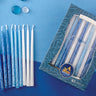 Handmade box of blue and white decorated Chanukah candles beside loose candles