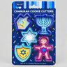 Five plastic Chanukah cookie cutters in dreidel, menorah, star, Maccabee and shield shapes on a Rite Lite card