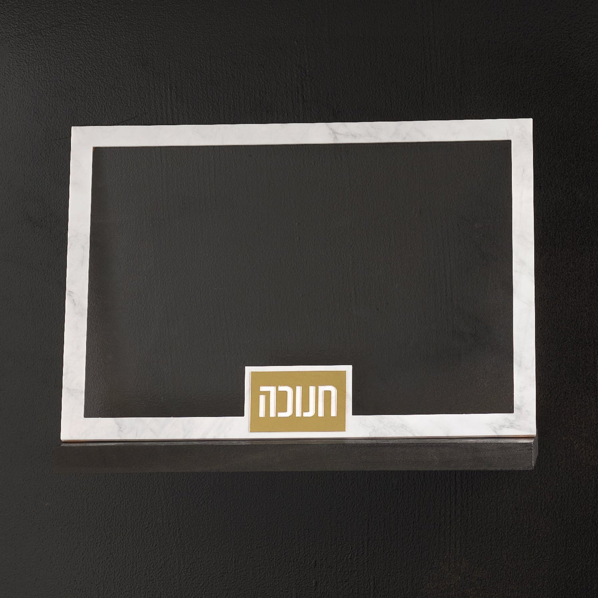 Lucite Chanukah tray with gold Chanukah plaque on a dark surface