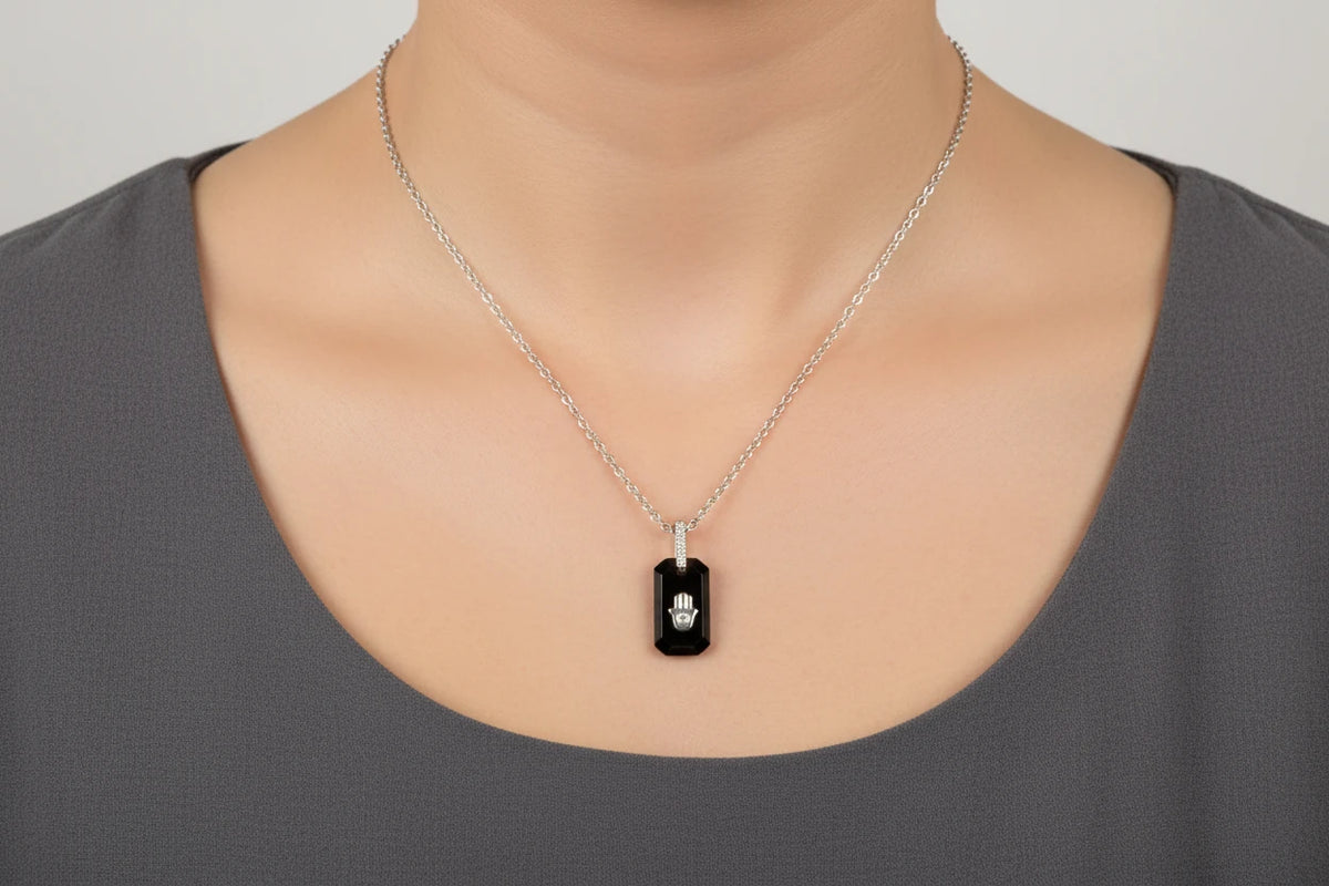 Black Onyx and CZ hamsa pendant sterling silver necklace, black onyx hamsa pendant worn on a grey top