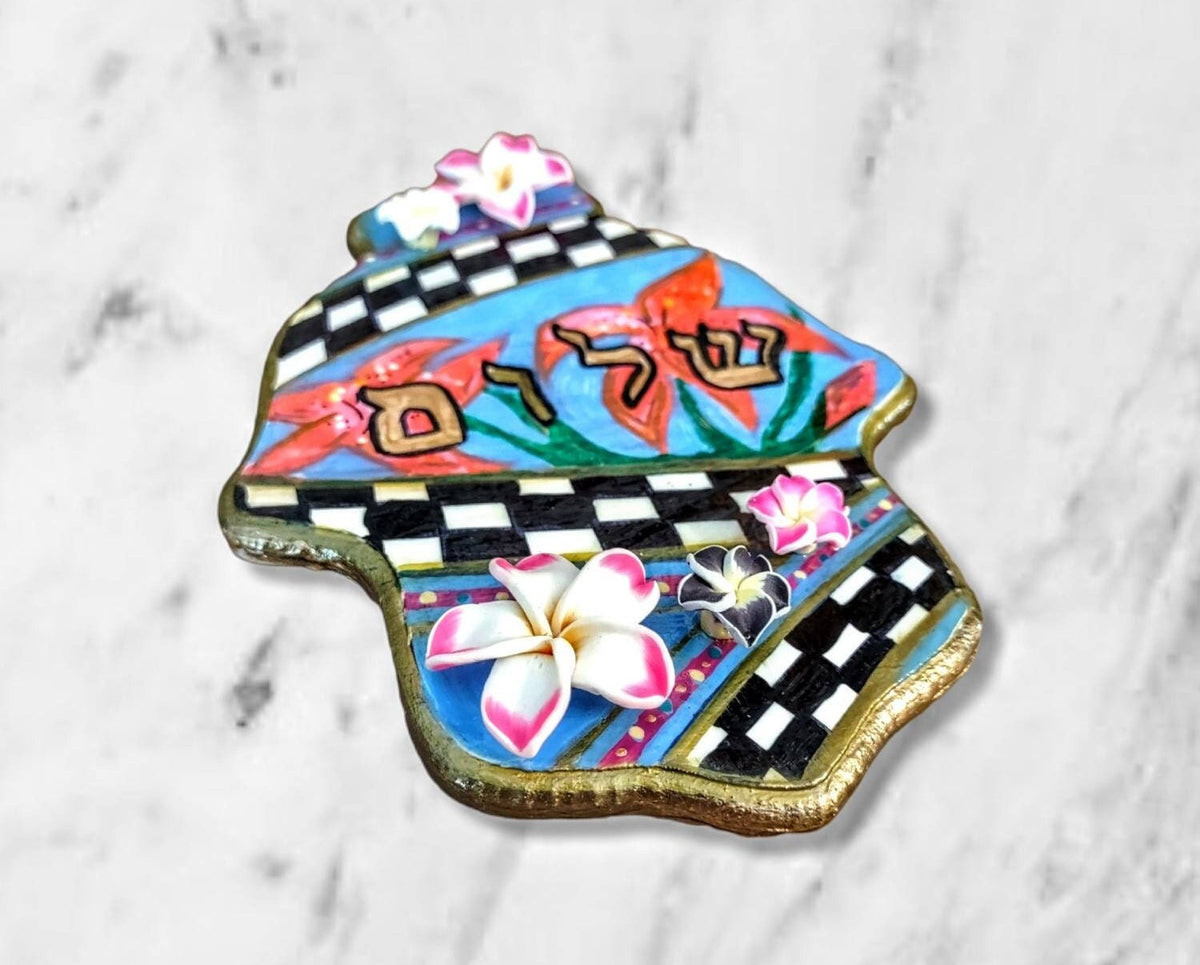 Checkered hamsa with pink flowers on marble