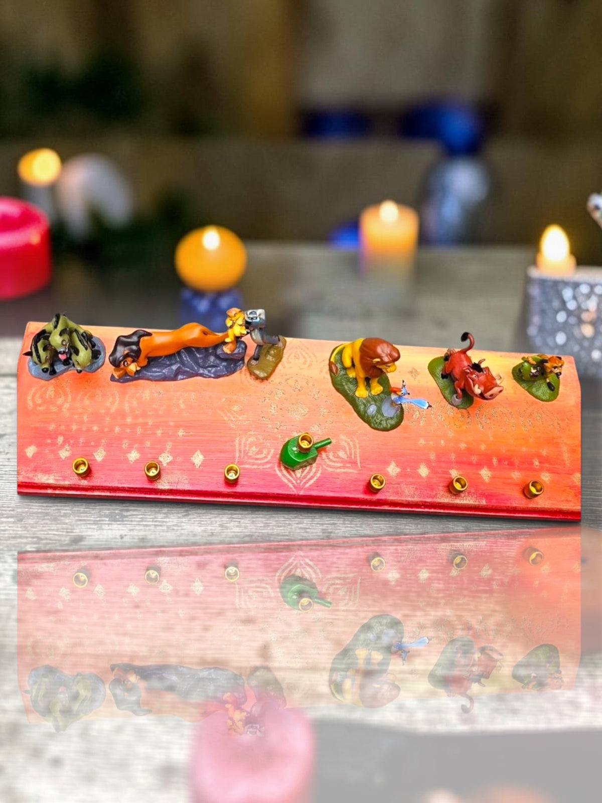 Collector’s Edition Lion King “Circle of Life” Menorah, Circle of Life menorah with lit candles in a warm candlelit setting