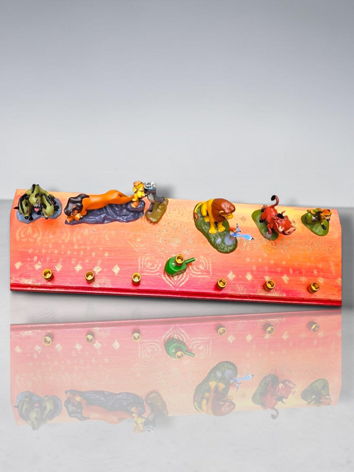 Collector’s Edition Lion King “Circle of Life” Menorah, Circle of Life menorah base and figures on a reflective surface