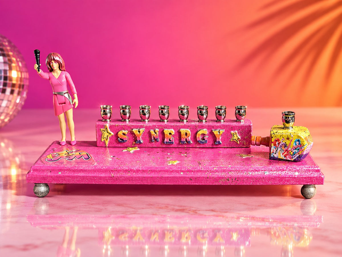 Collector’s Jem “Synergy” Menorah, pink Jem menorah with doll figure on a pink stage backdrop