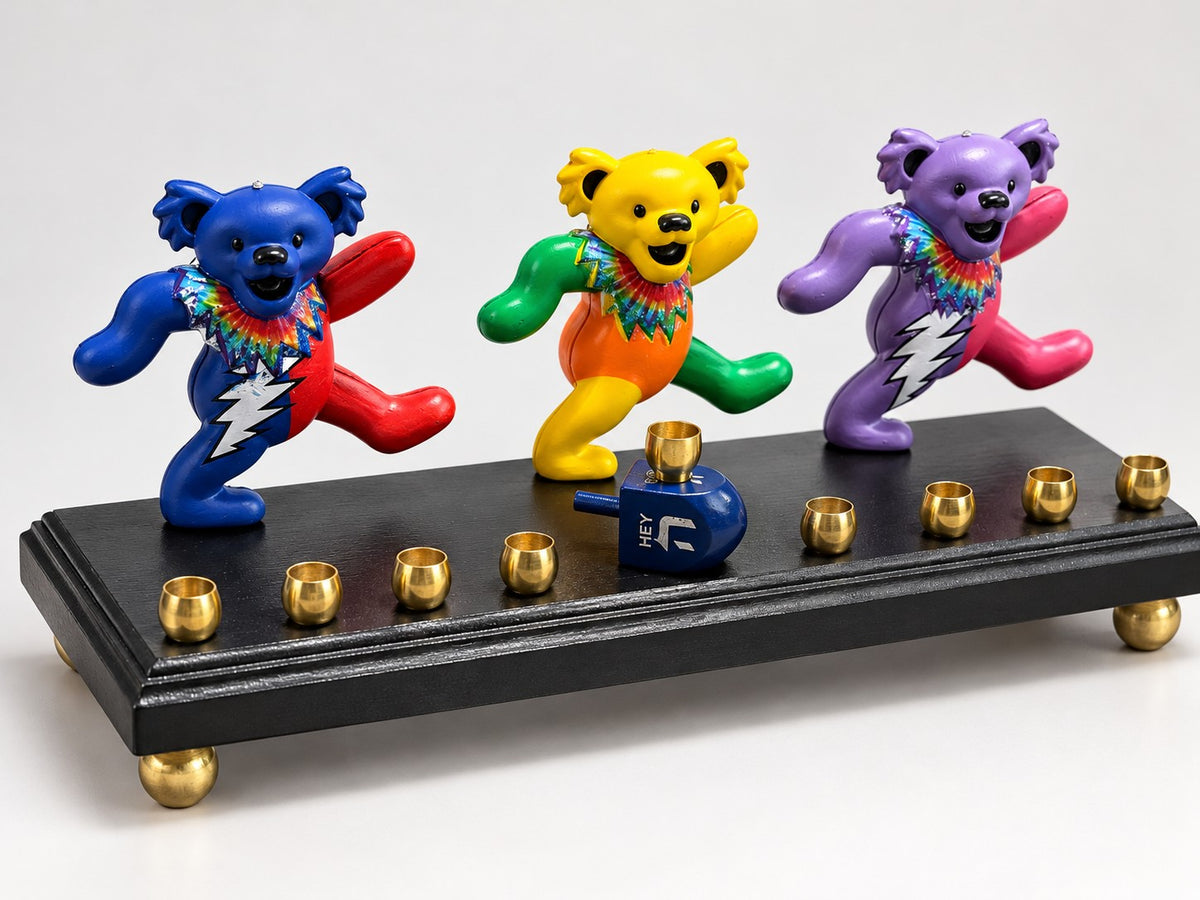 Dancing Bears Menorah, three dancing bear figures on a black base with brass cups on white
