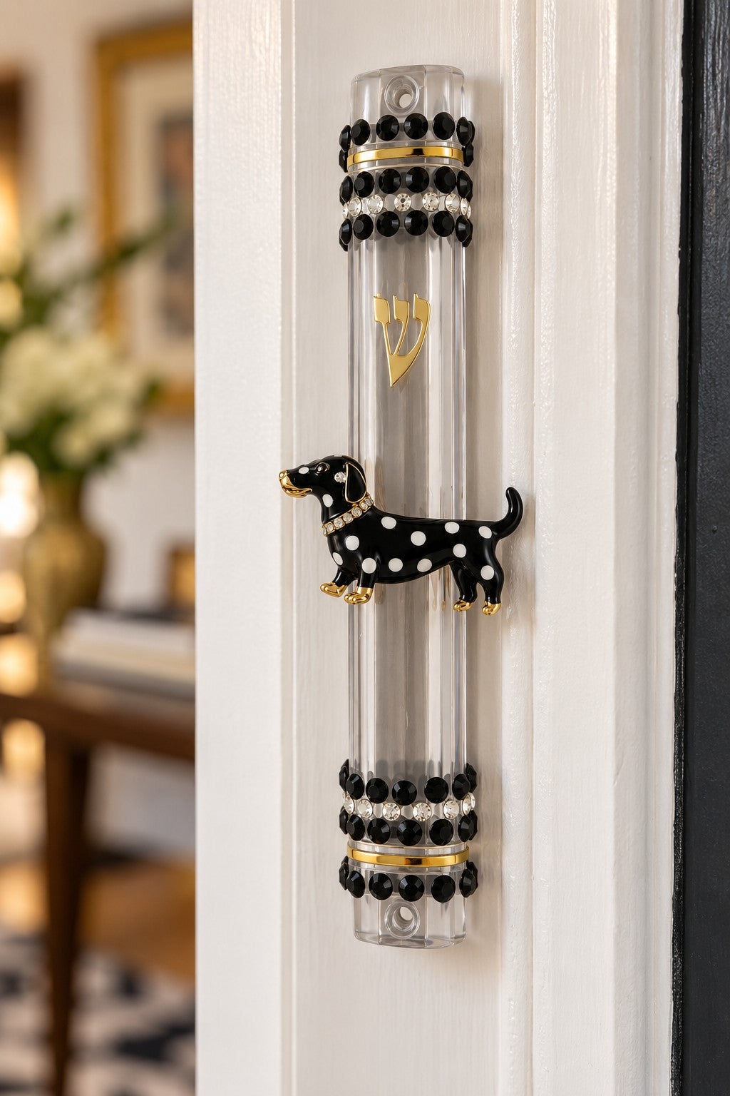 Clear tube mezuzah case with black-and-white dachshund on a white doorframe