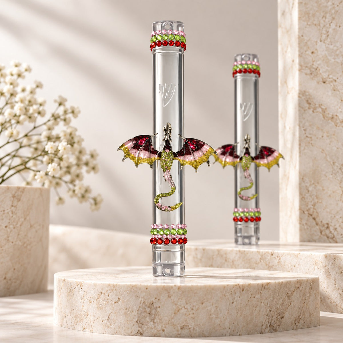 Two jeweled dragon mezuzah cases on stone