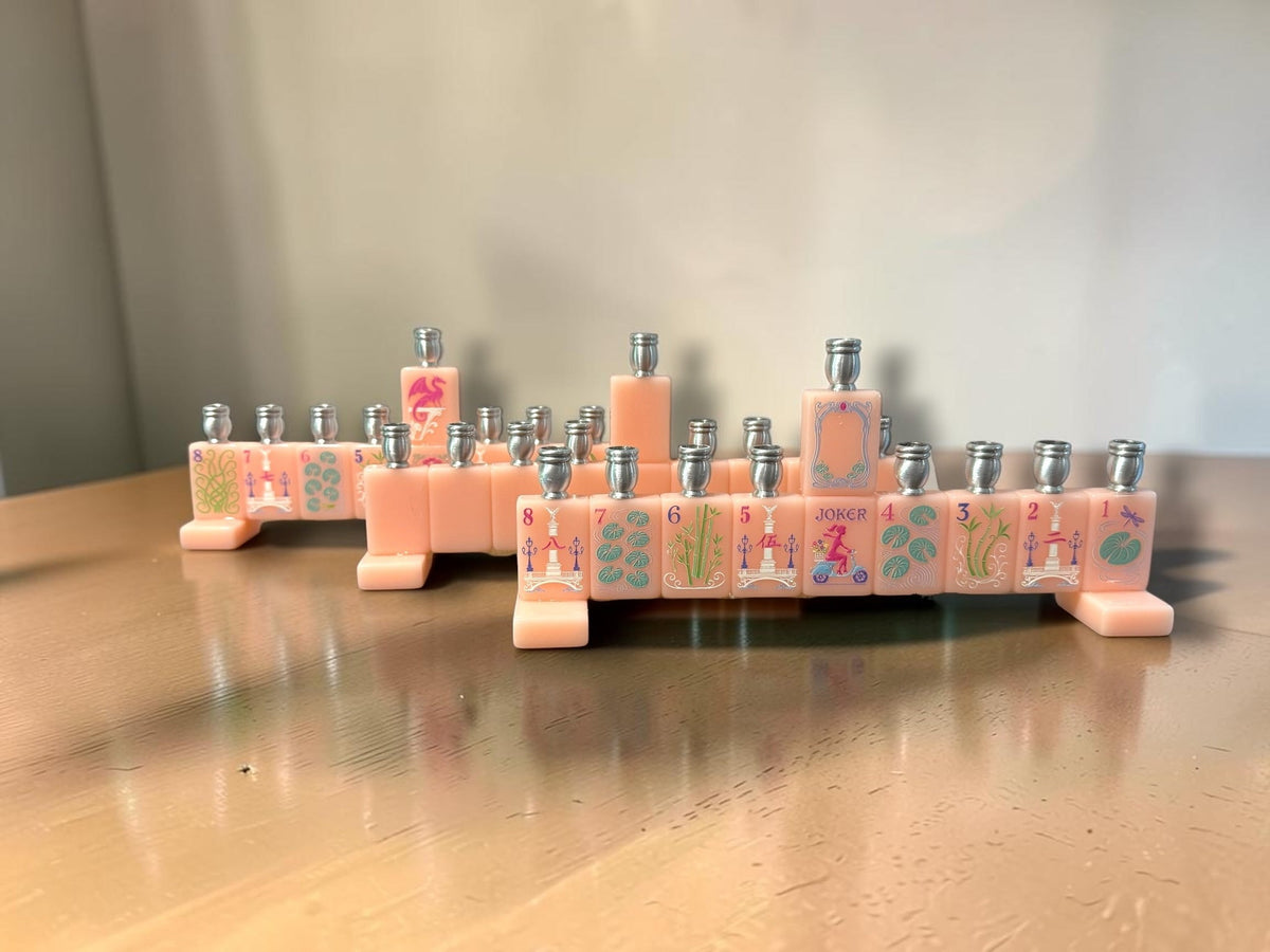 Pink mahjong tile menorah on a wood table