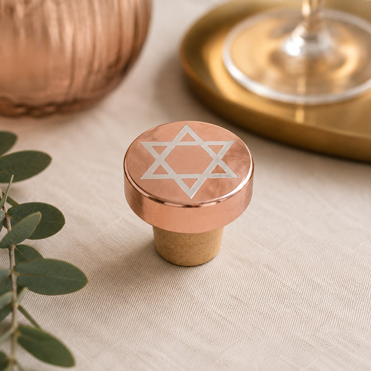 Metallic Star of David Wine Bottle Stopper, rose gold Star of David stopper beside a glass