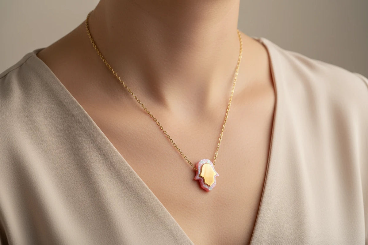 Pink opal hamsa necklace worn at the neckline
