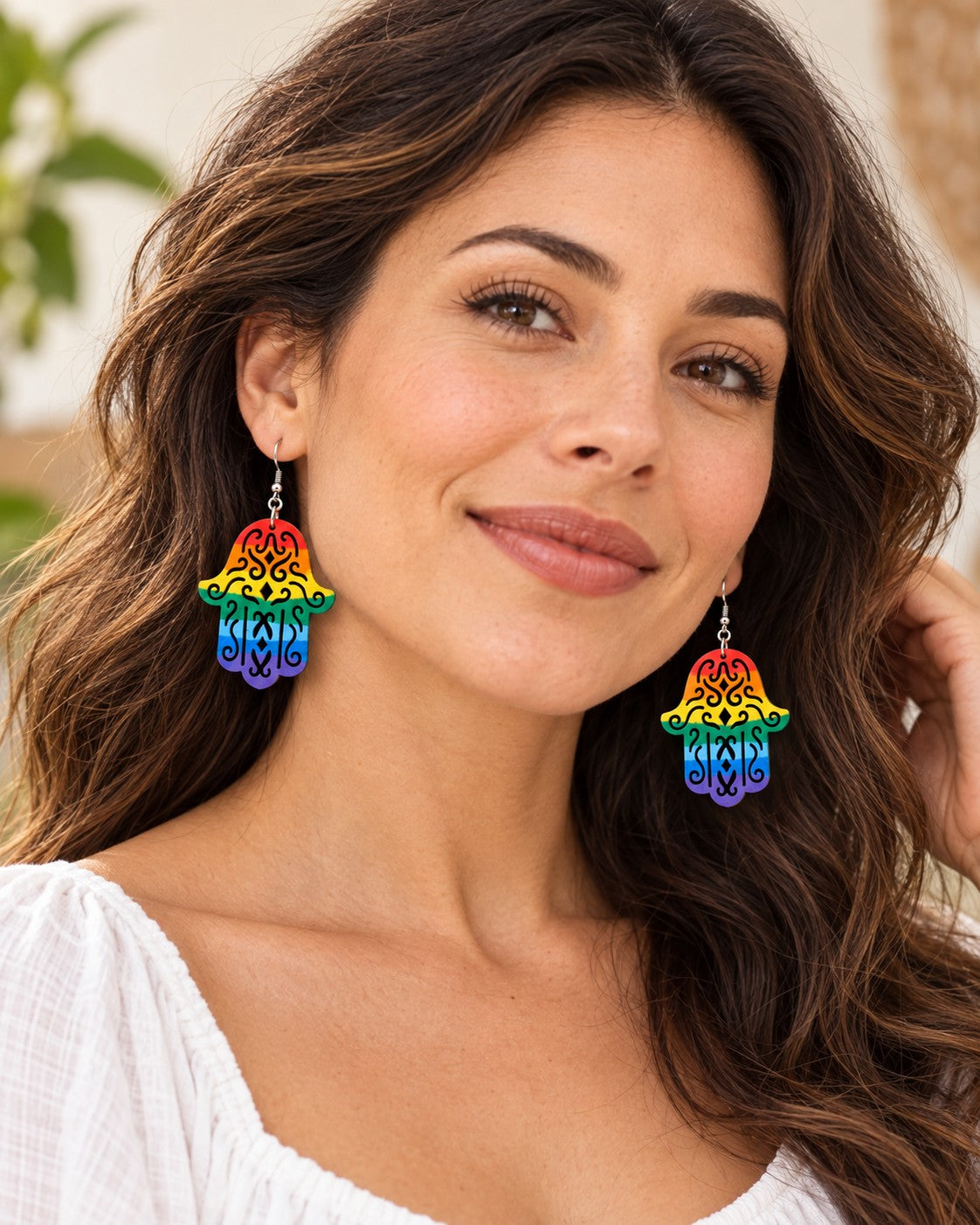 Woman wearing the rainbow hamsa earrings