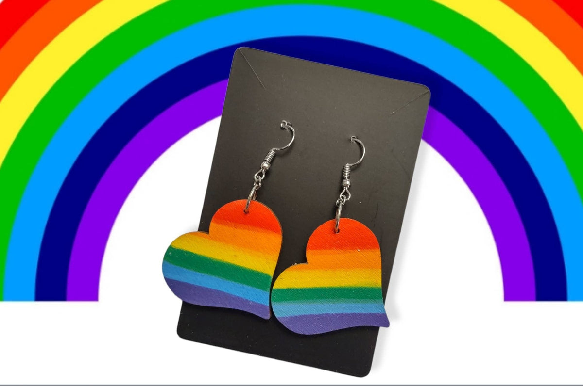 Rainbow heart earrings in front of a rainbow graphic