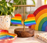 Rainbow heart earrings displayed beside a rainbow ornament