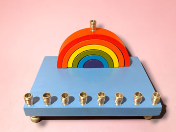 Rainbow arch on a light blue wood menorah base on pink