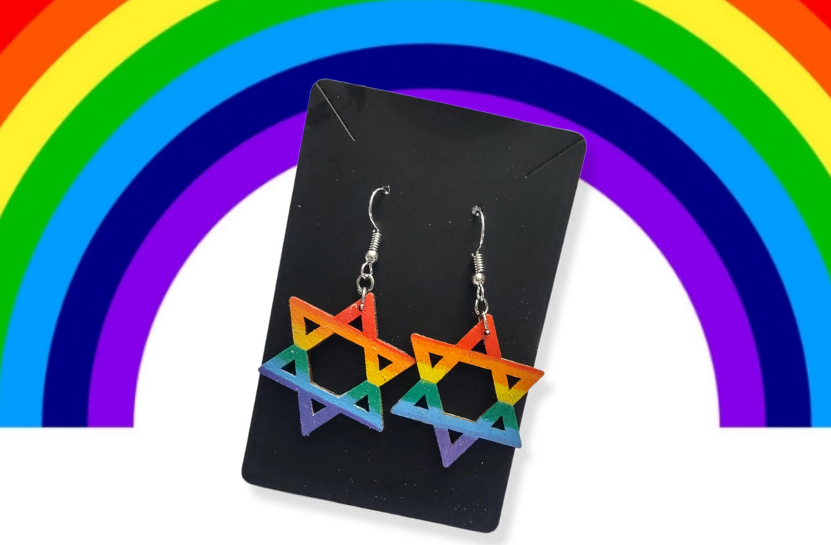 Rainbow star earrings on a card with a rainbow backdrop