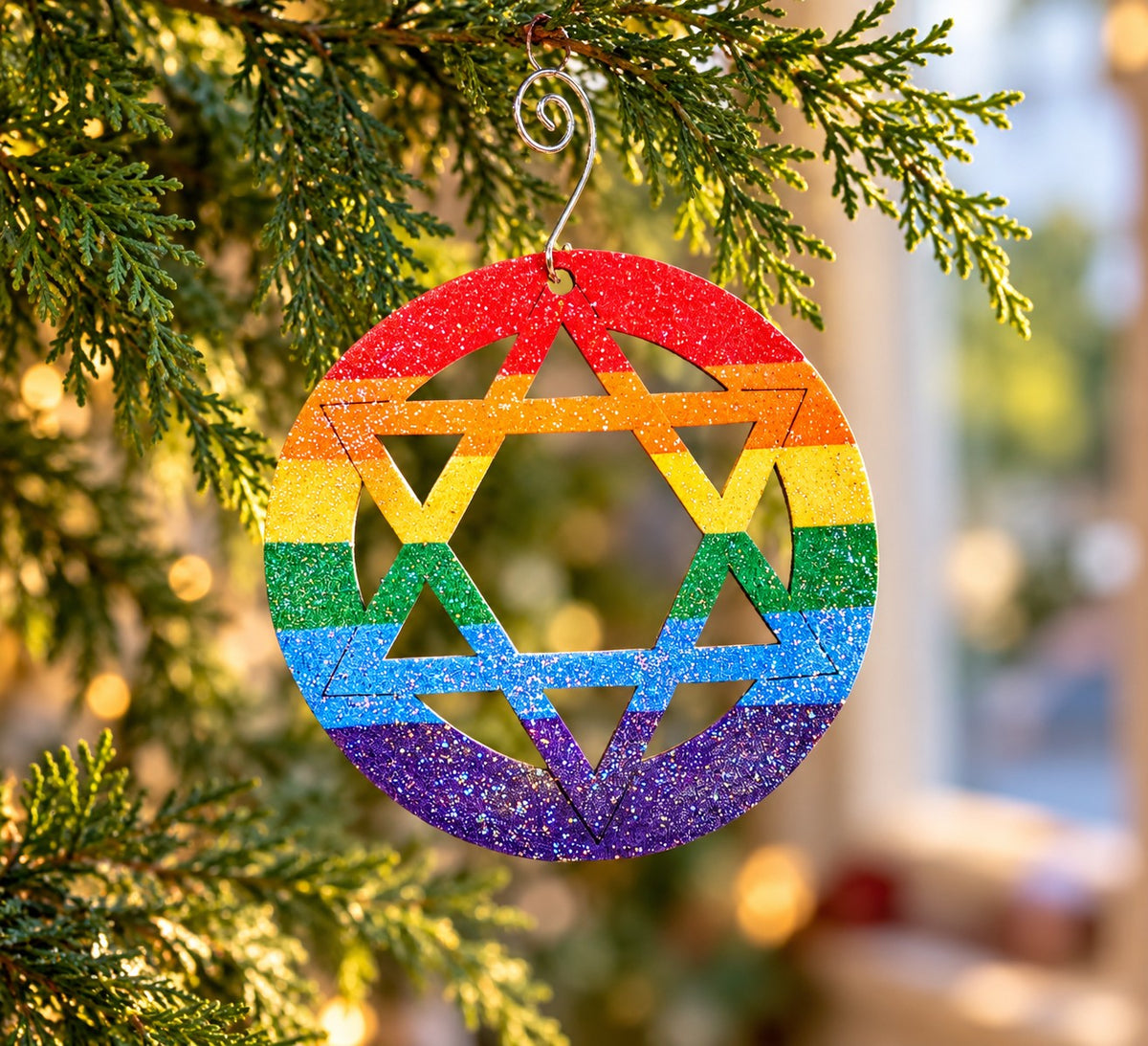 Rainbow star ornament hanging on evergreen