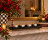 Red, black and gold dreidel menorah on a mantel