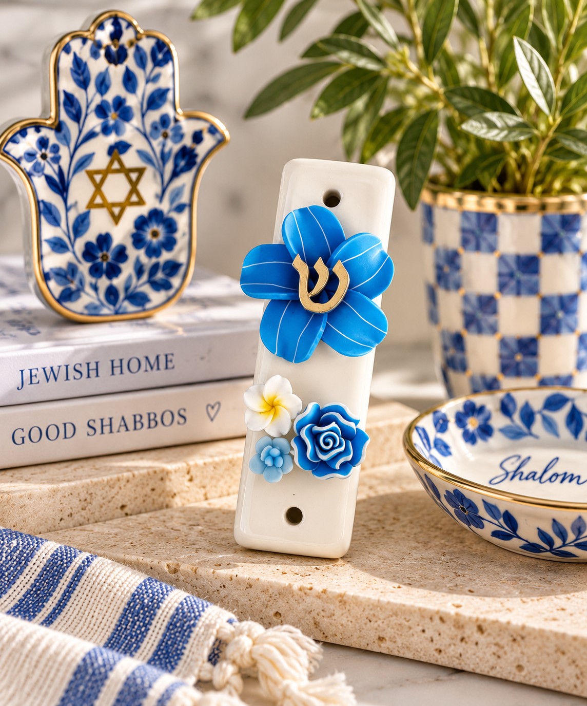 Shalom in Bloom Ceramic Mezuzah, blue floral ceramic mezuzah beside a hamsa