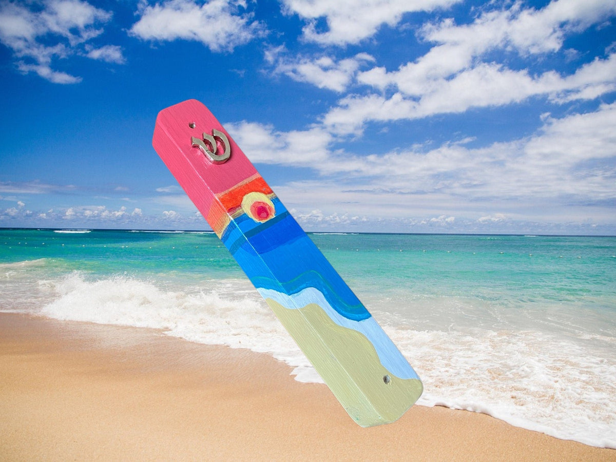 Shalom Shores mezuzah against a beach