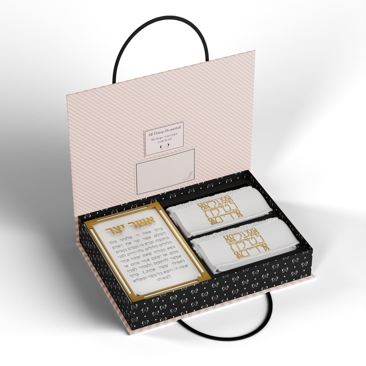 Open gift box showing the gold-framed Asher Yatzar card beside two folded towels