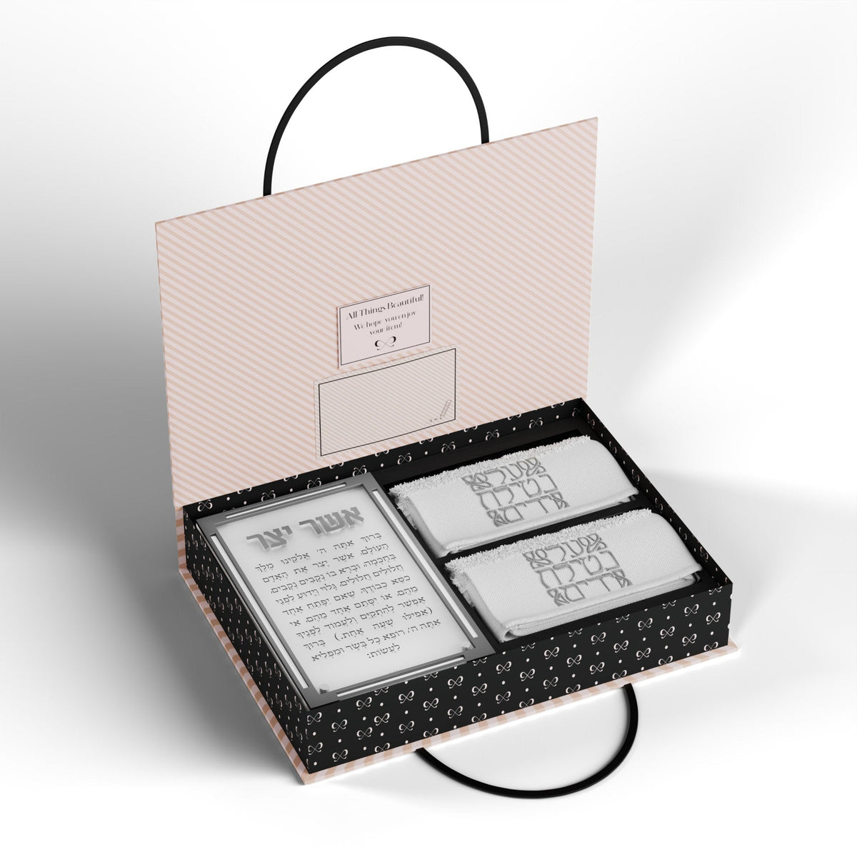 Open box with the silver Asher Yatzar card and two towels with silver lettering