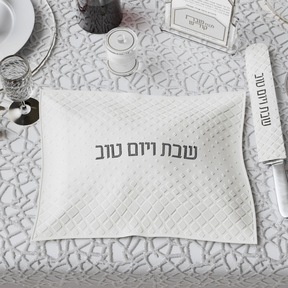 Black-lettered cover styled on a white lace tablecloth with wine, glassware and the knife cover