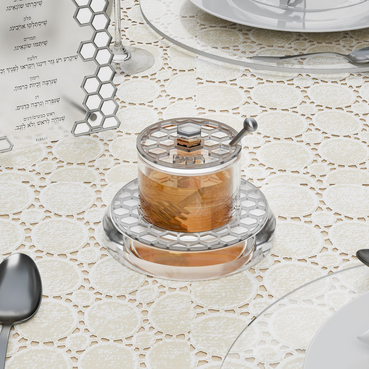 Silver honeycomb honey dish with honey beside a simanim card on a set table