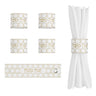 Four white napkin rings with gold honeycomb pattern and Shana Tova, one wrapped on a napkin