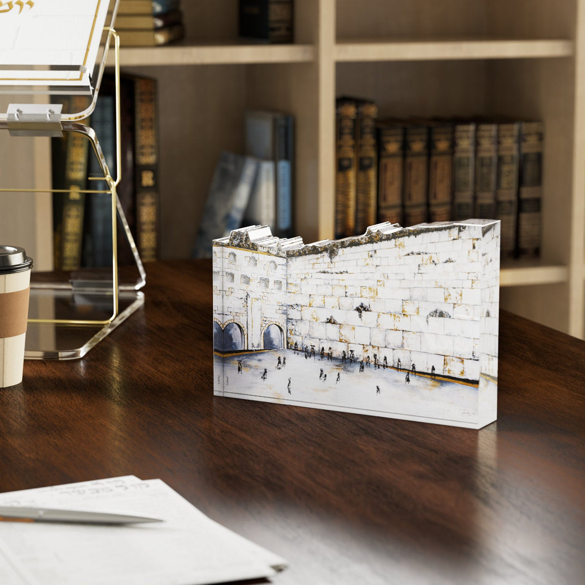 Kosel Hamaravi block on a dark wood desk in front of shelves of seforim