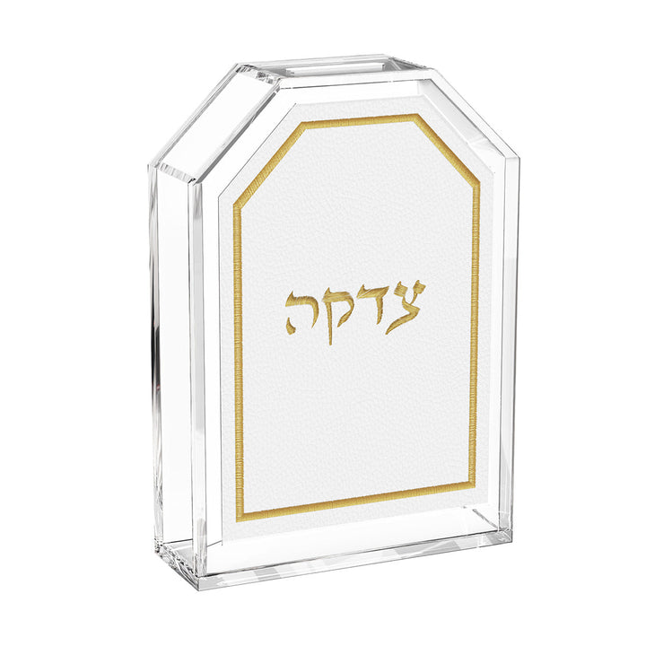 Leatherite tzedakah box in gold, Hebrew Tzedakah embroidered on white leather in a clear lucite case