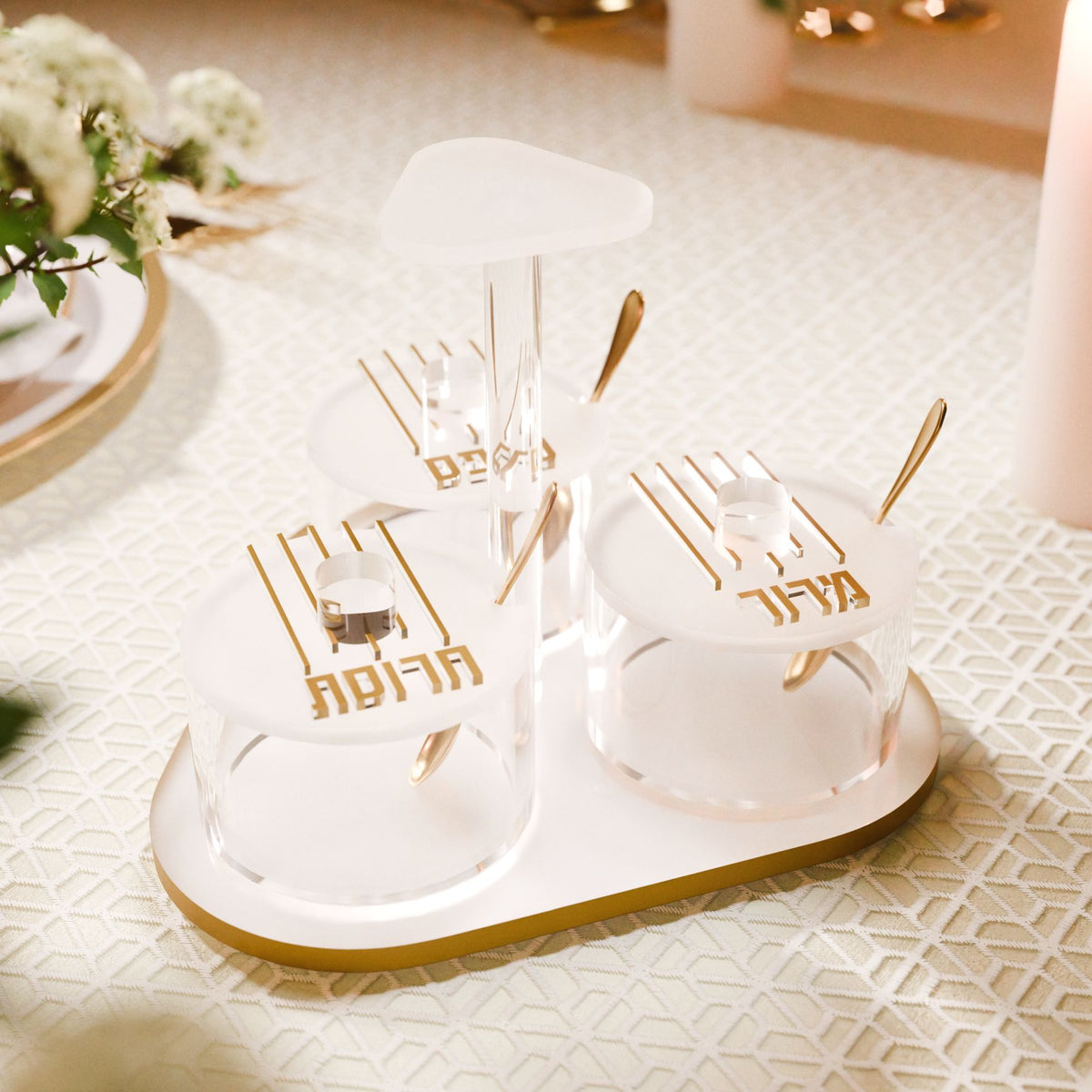 Gold dish set on a Seder table, labeled charoses, karpas and maror lids with gold spoons