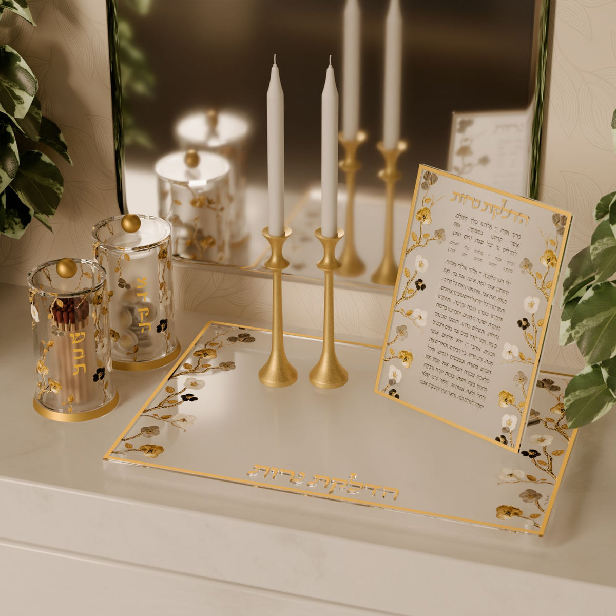 Tzedakah box on a counter beside gold candlesticks and the matching candle lighting tray and card