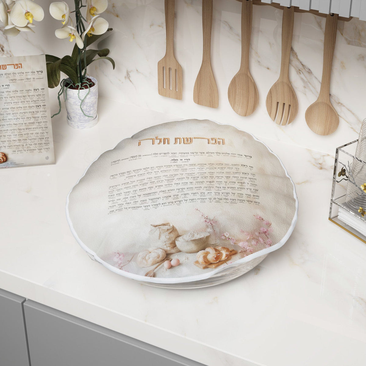 Cover stretched over a dough bowl on a marble counter beside the matching card and wooden utensils