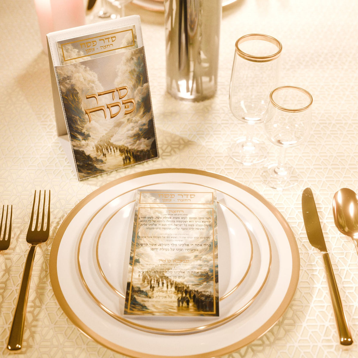 Yam Suf pouch and a Seder card on a gold-rimmed plate at a cream Pesach place setting