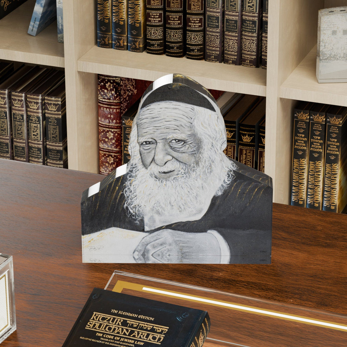 Rav Chaim Kanievsky block on a wooden desk in front of shelves of sefarim